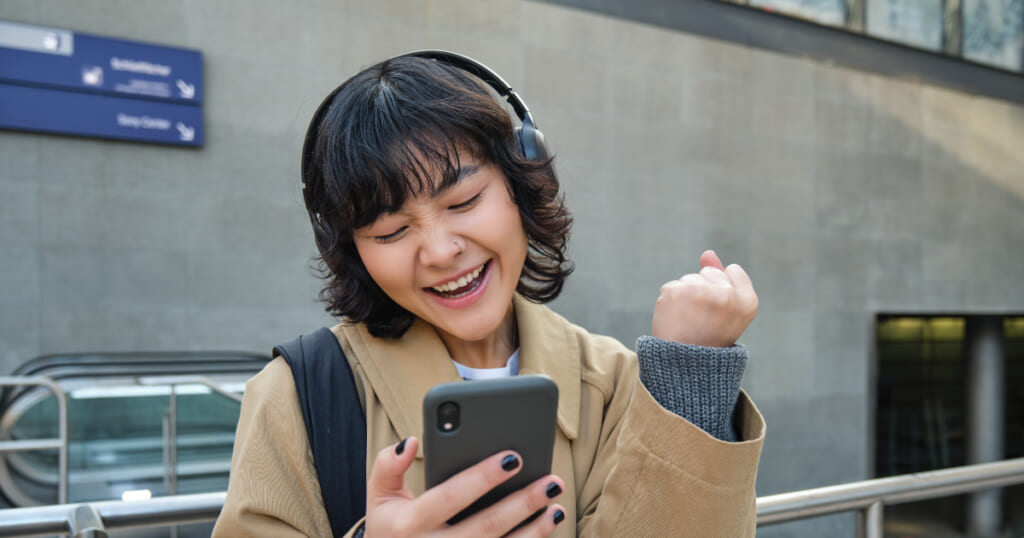 スマホを見て喜ぶ女性